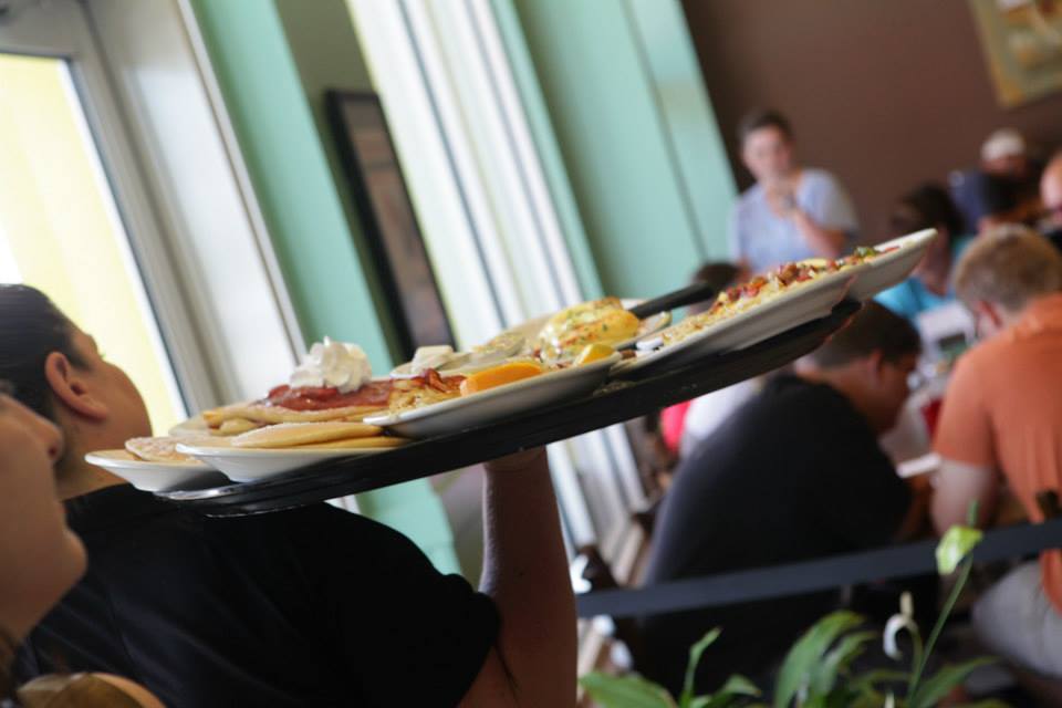 Staff members are visible serving food and attending to customers