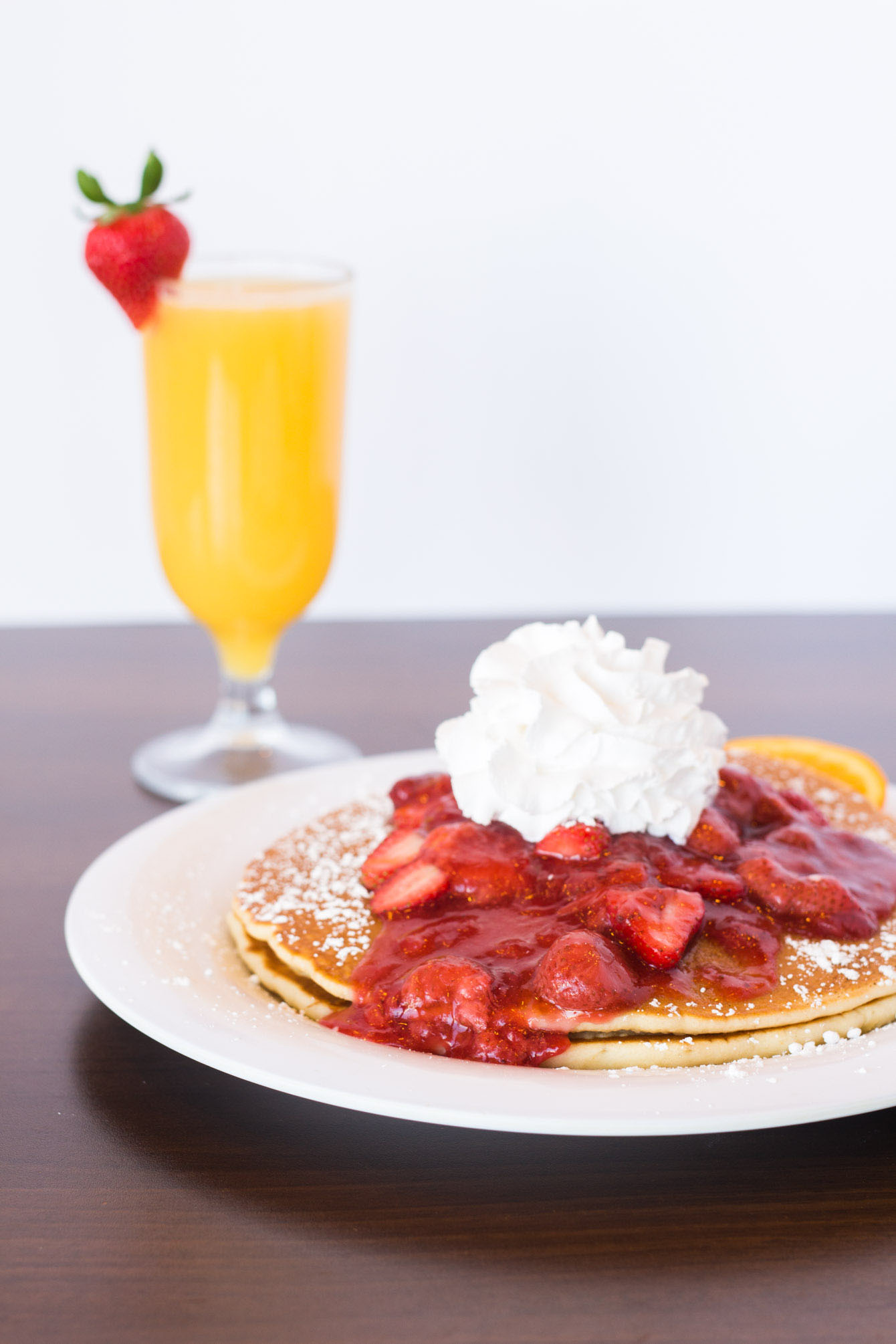 Pancakes topped with strawberry compote and whipped cream