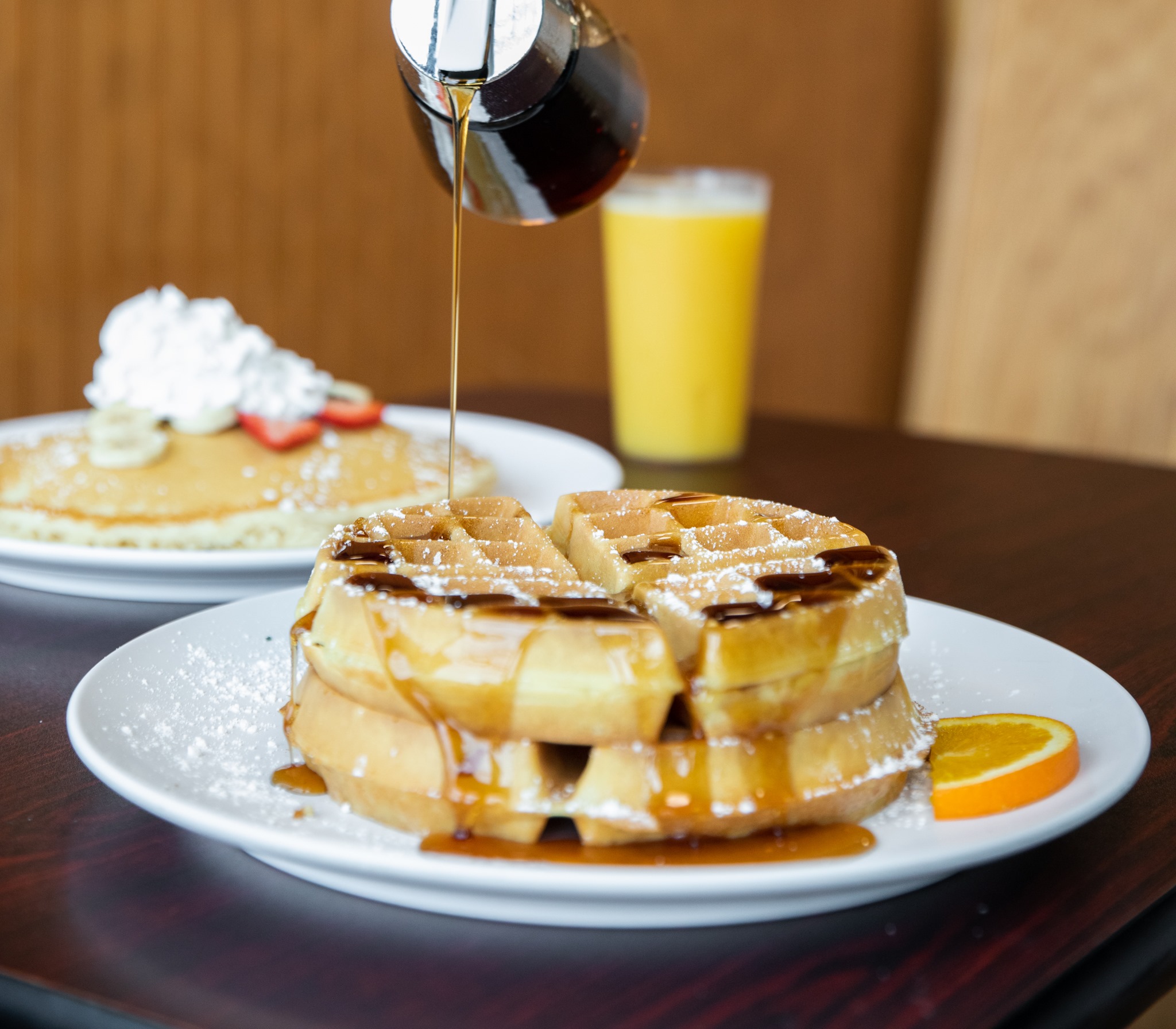 Stack of golden Belgian waffles topped with powdered sugar