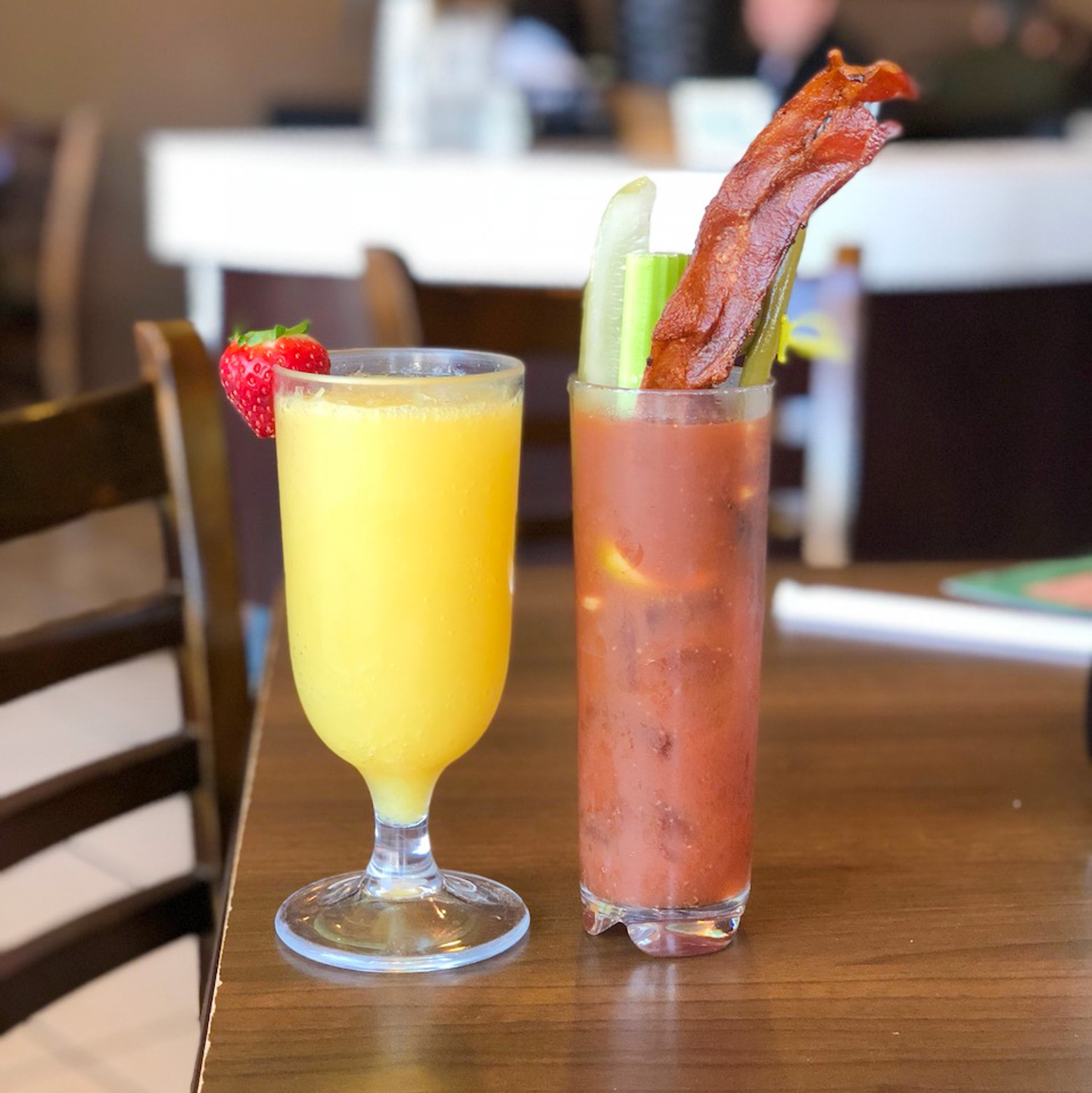 Two brunch cocktails on a wooden table